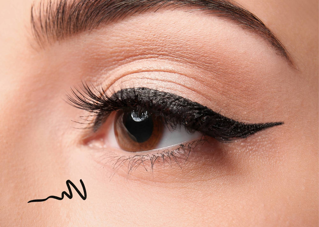 Model applying a sharp black cat eye eyeliner look inspired by Love Island.